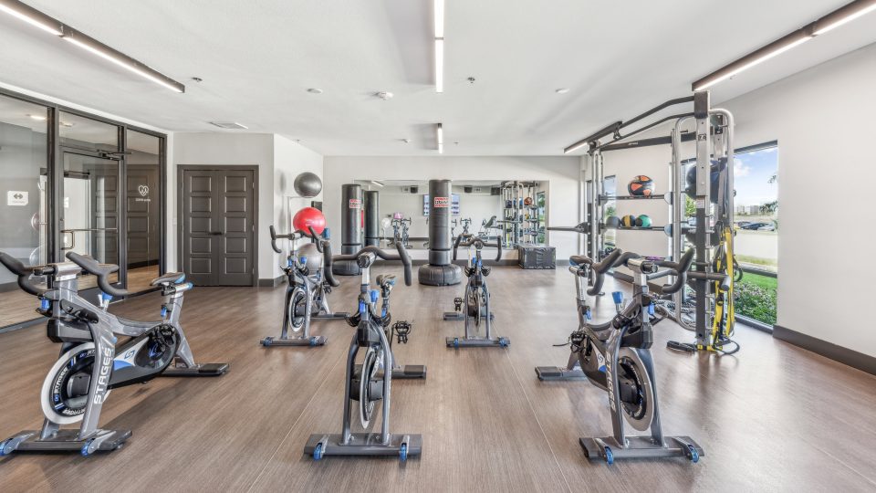 a gym room with exercise bikes and mirrors at The Terra at University North Park