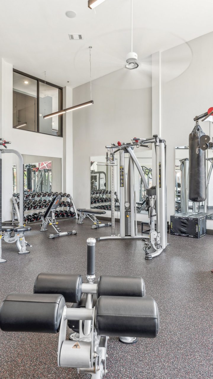 a gym room with a large exercise equipment and mirrors at The Terra at University North Park