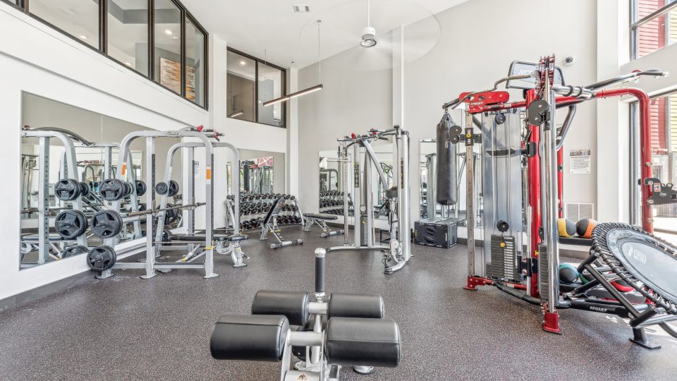 a gym room with a large exercise equipment and mirrors at The Terra at University North Park