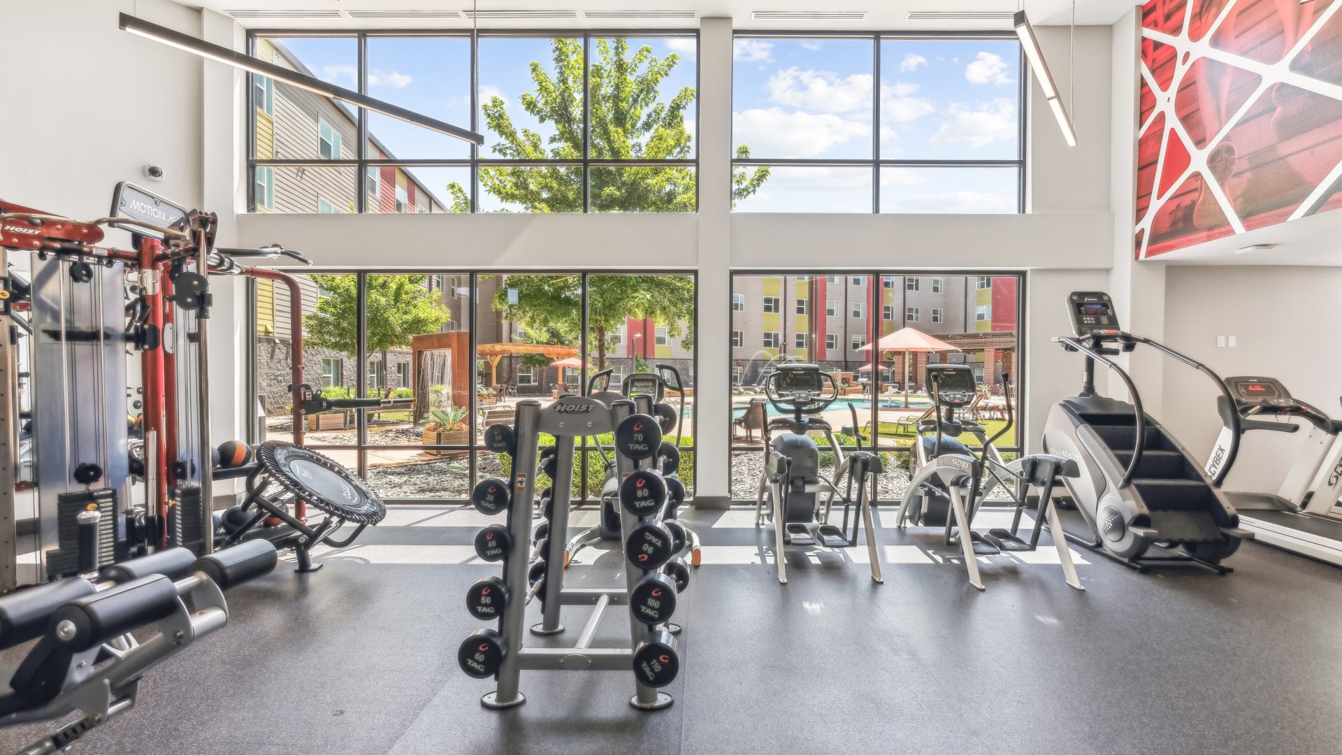 a gym room with a large window and exercise equipment at The Terra at University North Park