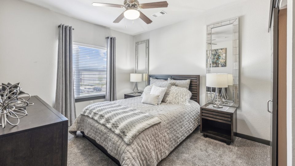 a bedroom with a ceiling fan and a large bed at The Terra at University North Park